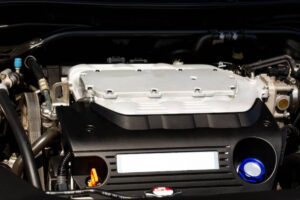 Close-up of a car engine showcasing the aluminum intake manifold, hoses, and various engine components in a sleek design.