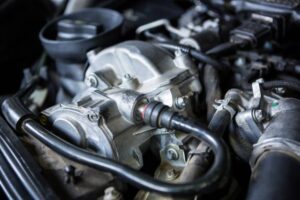 Close-up of an engine's throttle body and surrounding components, showcasing intricate metallic parts and connected hoses.